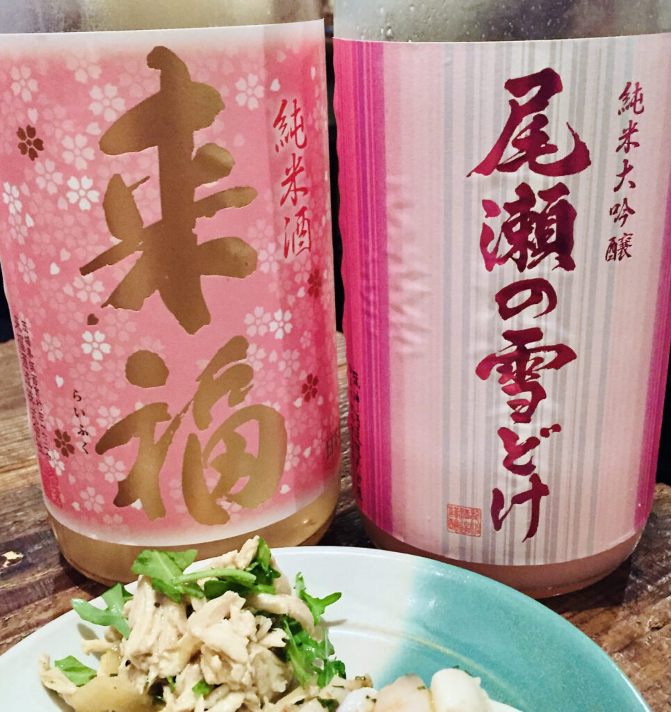 桃色のラベルの日本酒の瓶とお料理